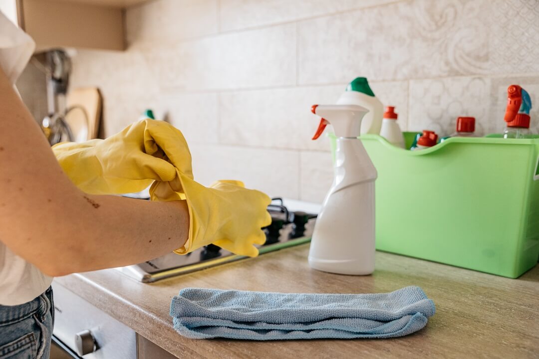 Woman wearing gloves cleaning the kitchen
