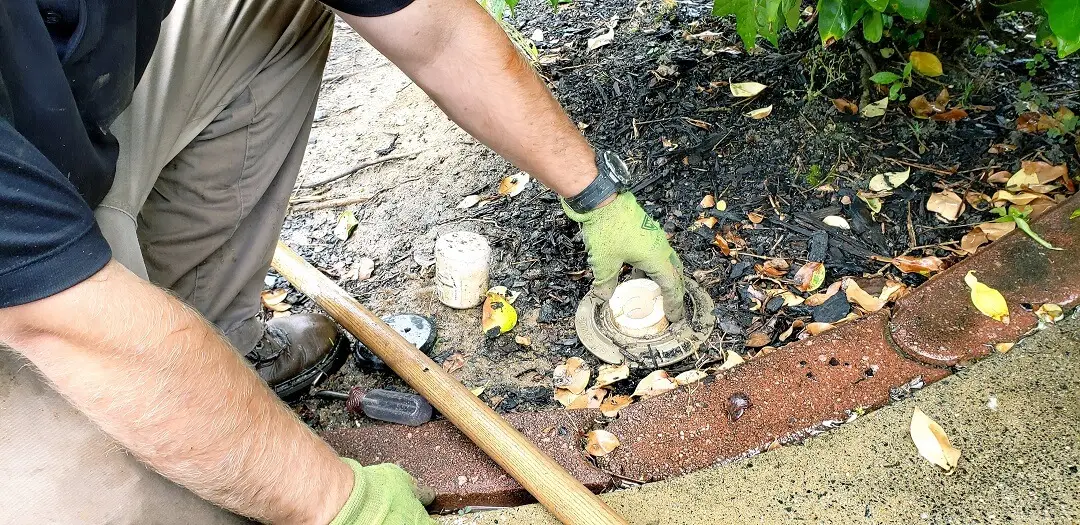 A man inserting termite traps at home